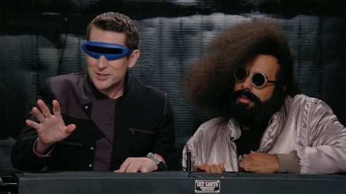 Reggie Watts Wears a Purple and Yellow Quilted Sweatshirt